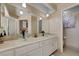 Bright bathroom with a double sink vanity and a door leading to a separate shower/tub area at 9333 Dry Dock Dr, Las Vegas, NV 89117