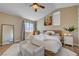 Sunlit bedroom with a ceiling fan, a window with curtains, and a cozy rug at 9333 Dry Dock Dr, Las Vegas, NV 89117