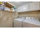 Functional laundry area equipped with a washer, dryer, and ample shelving for storage at 9333 Dry Dock Dr, Las Vegas, NV 89117