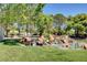Picturesque pond with rock waterfall feature and lush green landscaping surrounded by mature trees at 9333 Dry Dock Dr, Las Vegas, NV 89117