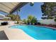 Backyard featuring a stunning pool with ample lounge space, privacy landscaping, and an outdoor cooking area at 9333 Dry Dock Dr, Las Vegas, NV 89117