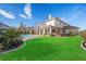 Expansive backyard, showcasing green lawn and landscaped patio with a built-in grill station and inviting pool at 9605 Verlaine Ct, Las Vegas, NV 89145