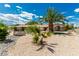 Landscaped home exterior with decorative rock, vibrant palms, and partial fencing at 9660 W Ann Rd, Las Vegas, NV 89149