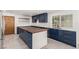 Renovated kitchen features blue cabinets, stainless appliances, and a large island at 9660 W Ann Rd, Las Vegas, NV 89149