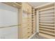 Bright walk-in closet with wood storage, drawers and gold hardware for maximum storage capacity at 9660 W Ann Rd, Las Vegas, NV 89149