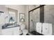 Modern bathroom with marble-like tile shower, black finishes, and decorative mirror at 12212 Elderwood St, Las Vegas, NV 89138