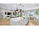Open-concept kitchen featuring a large island with marble countertop, stainless steel appliances, and adjacent living and dining areas at 12212 Elderwood St, Las Vegas, NV 89138