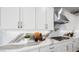 Beautiful kitchen counter with white cabinets, marble backsplash, stainless steel appliances, and designer fixtures at 12212 Elderwood St, Las Vegas, NV 89138