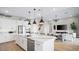 Spacious kitchen with a large marble island, white cabinets, stainless steel appliances, and open to the living area at 12212 Elderwood St, Las Vegas, NV 89138