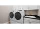 Convenient laundry room with modern washer and dryer, ample cabinet space, and a sink at 12212 Elderwood St, Las Vegas, NV 89138