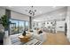 Bright living room with white sectional sofa, modern light fixture, and access to the outdoor space at 12212 Elderwood St, Las Vegas, NV 89138