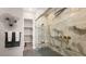 Luxurious walk-in shower with stone-patterned tile, glass enclosure, and bronze fixtures, adjacent to a walk-in closet at 12212 Elderwood St, Las Vegas, NV 89138