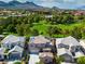 Stunning aerial view of a home with a pool, lush green surroundings, and mountains in the distance at 1551 Boundary Peak Way, Las Vegas, NV 89135