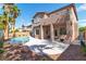 Beautiful backyard featuring a sparkling pool with rock accents, a covered patio, and manicured landscaping at 1551 Boundary Peak Way, Las Vegas, NV 89135