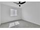 Simple bedroom featuring neutral carpet, a ceiling fan, and a window overlooking the neighborhood at 1551 Boundary Peak Way, Las Vegas, NV 89135
