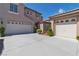 Spacious driveway leading to a well-maintained home with multiple garage doors and manicured landscaping at 1551 Boundary Peak Way, Las Vegas, NV 89135