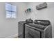 Modern laundry room with front load washer and dryer, storage shelf and window at 1551 Boundary Peak Way, Las Vegas, NV 89135
