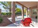 Covered patio featuring a red chair with views of the private pool and lush landscaping at 1551 Boundary Peak Way, Las Vegas, NV 89135