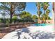 Inviting pool area with rock waterfall feature, surrounded by lush landscaping and mature trees at 1551 Boundary Peak Way, Las Vegas, NV 89135