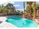 Inviting pool area with a rock waterfall feature, surrounded by lush greenery and palm trees at 1551 Boundary Peak Way, Las Vegas, NV 89135