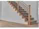 Carpeted staircase with wooden handrail and modern black metal balusters at 1551 Boundary Peak Way, Las Vegas, NV 89135