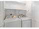 Laundry room with white washer and dryer, overhead shelf, and white shutters at 2152 High Dunes Ln, Laughlin, NV 89029