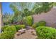 Serene backyard with lush greenery, stone accents, bench and water fountain feature at 2225 Blackburn Hills Ave, Henderson, NV 89044