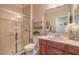 Well-lit bathroom featuring a glass shower and vanity with a warm wood finish at 2225 Blackburn Hills Ave, Henderson, NV 89044