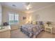 Cozy bedroom featuring a ceiling fan, floral bedding and bright natural light at 2225 Blackburn Hills Ave, Henderson, NV 89044