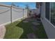 Private backyard featuring artificial turf, a stone-paved patio, and white fencing, perfect for outdoor enjoyment at 226 Callen Falls Ave # 1311, Henderson, NV 89011