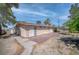Backyard view of house featuring red concrete patio, mature trees, and block fence at 2880 Placita Ct, Las Vegas, NV 89121