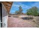A spacious backyard with trees, bordered by a red concrete patio. Perfect for outdoor activities at 2880 Placita Ct, Las Vegas, NV 89121