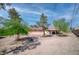 Rear exterior view of home with trees, red tile roof, and covered patio seating at 2880 Placita Ct, Las Vegas, NV 89121