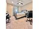 Bedroom with neutral walls, carpeted flooring, and ceiling fan with a black metal bed and desk workspace at 3114 Molinos Dr, Las Vegas, NV 89141