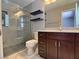 Updated bathroom with glass shower, floating shelves, granite vanity, and dark wood cabinets at 349 Esquina Dr, Henderson, NV 89014