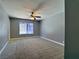 Spacious bedroom with neutral carpet, ceiling fan, and bright window at 349 Esquina Dr, Henderson, NV 89014
