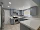 Updated kitchen featuring stainless steel appliances, tile countertops, and modern lighting at 349 Esquina Dr, Henderson, NV 89014