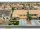 Aerial shot highlighting a well-manicured home with a tiled roof, three-car garage, and lush landscaping at 3692 River Canyon Rd, Las Vegas, NV 89129