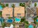 An aerial view features the rooftops of adjacent homes with well-manicured yards and private pools at 3692 River Canyon Rd, Las Vegas, NV 89129