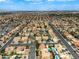 Expansive aerial view showcases a large residential community with tree-lined streets, pools and mountain views at 3692 River Canyon Rd, Las Vegas, NV 89129
