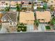 An aerial view showcasing houses with orange roofs, green yards, and swimming pools in a desert climate at 3692 River Canyon Rd, Las Vegas, NV 89129