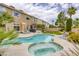Expansive backyard featuring a sparkling pool, spa, lush lawn, and patio area for outdoor entertaining at 3692 River Canyon Rd, Las Vegas, NV 89129