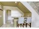 Inviting wet bar with granite counters and seating under the stairs at 3692 River Canyon Rd, Las Vegas, NV 89129