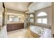 Luxurious bathroom featuring a soaking tub, glass-enclosed shower, and elegant vanity at 3692 River Canyon Rd, Las Vegas, NV 89129