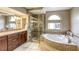 Luxurious bathroom featuring a soaking tub, glass-enclosed shower, and elegant vanity at 3692 River Canyon Rd, Las Vegas, NV 89129