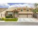 Inviting two-story home featuring a three-car garage, manicured lawn, and stone accents at 3692 River Canyon Rd, Las Vegas, NV 89129