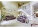 Bright living room with soaring ceilings, a staircase, and comfortable seating at 3692 River Canyon Rd, Las Vegas, NV 89129