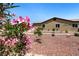 Backyard showing colorful flower bushes, drought tolerant plants and the home's tan exterior at 4317 Velvet Ridge Ct, Las Vegas, NV 89129