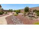 Picturesque backyard featuring a tranquil waterfall, gravel paths, and lush greenery at 4317 Velvet Ridge Ct, Las Vegas, NV 89129