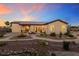Inviting backyard with desert landscaping, a stone patio, and outdoor seating at sunset at 4317 Velvet Ridge Ct, Las Vegas, NV 89129
